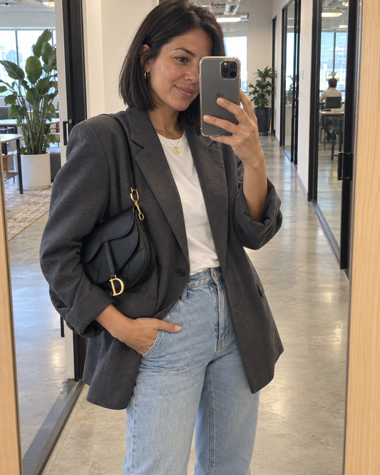 AI-generated styling illustration: black Heritage Saddle Bag in a casual work outfit.