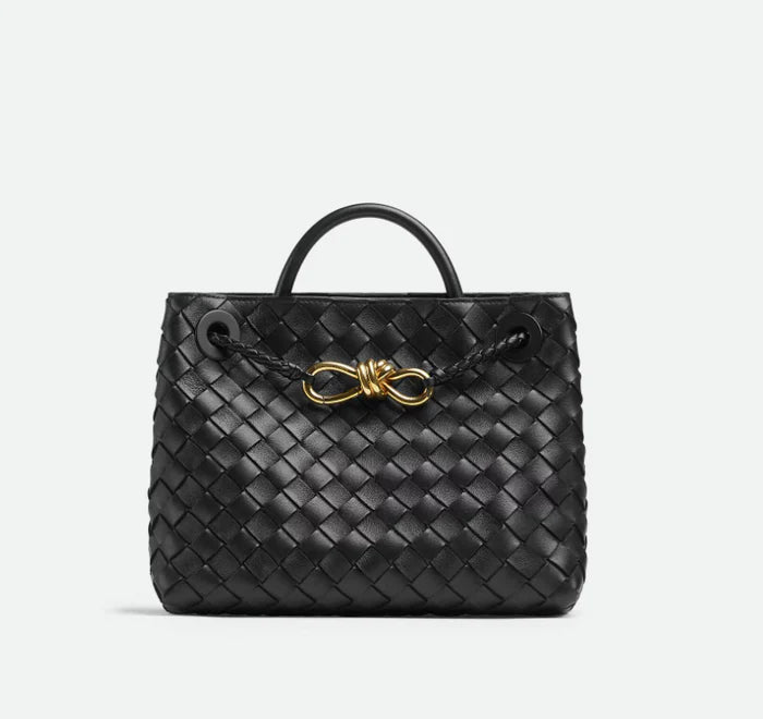 Wine burgundy woven leather tote bag with top handle, gold knot detail, and long braided shoulder strap, luxury inspired handbag for women.
