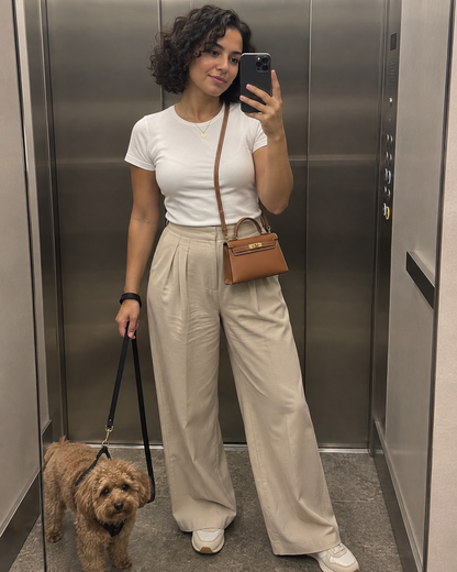 AI-generated styling illustration: brown Mini Kelly worn with its strap before a dog walk.