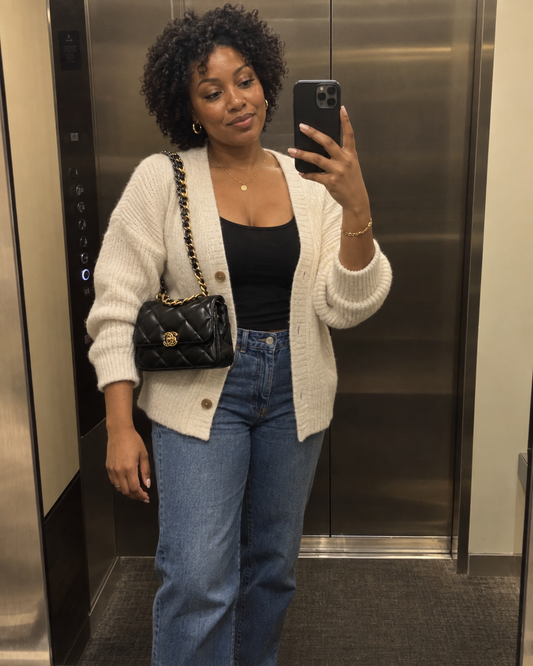 AI-generated styling illustration: black quilted chain shoulder bag in a casual elevator outfit.